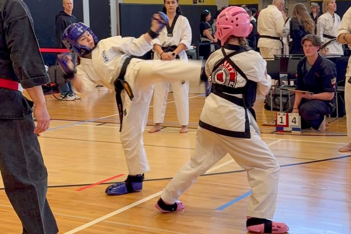 Two competitors point sparring, one landing a kick
