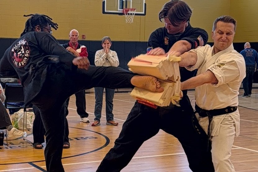 Competitor breaking a stack of boards with a roundhouse kick